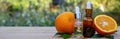 bottle of aromatic essence and fresh orange on the background of nature. Royalty Free Stock Photo