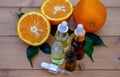 bottle of aromatic essence and fresh orange on the background of nature. Royalty Free Stock Photo