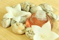 Bottle of aromatic oil, stones, flowers. Royalty Free Stock Photo