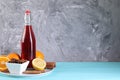Bottle of aromatic punch drink and ingredients on blue table, space for text Royalty Free Stock Photo