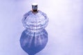Bottle of aromatic scent perfume in bottle made of glass on violet background. Purple photo