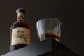 A bottle of barrel proof bourbon sitting next to a filled rocks glass