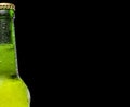 Bottle of beer with drops on a black background. Close up part of the bottle. Royalty Free Stock Photo