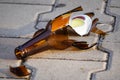 Bottle of beer, soda or drugs from dark glass is broken. Shattered beer bottle on ground in sunset light. Fragments of glass on Royalty Free Stock Photo