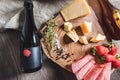 A bottle of beer and a variety of snacks on a wooden tray stand on the table. The concept of food and snacks, table