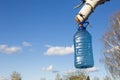 a bottle of birch sap hanging on a tree in early spring while collecting nectar against a blue sky Royalty Free Stock Photo