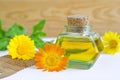 Bottle of calendula oil and wooden hair comb (Pot marigold extract, tincture, infusion)
