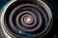 A bottle cap unscrewing into a spiral galaxy