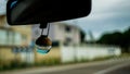 Bottle of car air freshener hanging from the mirror
