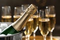Bottle of champagne in bucket with ice and glasses on blurred background. Royalty Free Stock Photo