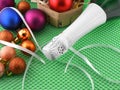 Bottle of champagne and Christmas balls on green background Royalty Free Stock Photo