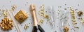 Bottle of champagne with colored glitter, confetti and gift box space for text on colorfull background, top view Royalty Free Stock Photo