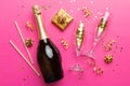 Bottle of champagne with colored glitter, confetti and gift box space for text on colorfull background, top view Royalty Free Stock Photo