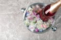 Bottle of champagne with floral ice cubes in bucket on table, top view