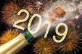 Bottle of champagne with flying cork and firework at Silvester 2019 Royalty Free Stock Photo