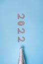 bottle of champagne in foil on a blue background with silver numerals 2022. New Years celebration or party. Royalty Free Stock Photo