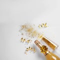 Bottle of champagne, glass with gold glitter and space for text on white background. Hilarious celebration Royalty Free Stock Photo
