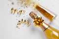 Bottle of champagne and glass with gold glitter on white background, top view. Hilarious Royalty Free Stock Photo