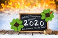 Bottle of champagne with glasses cork and blackboard german greeting frohes neues jahr 2020 greetings english translation: happy Royalty Free Stock Photo