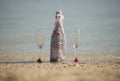 Bottle of champagne and glasses on a tropical beach Royalty Free Stock Photo