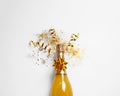 Bottle of champagne with gold glitter and bow on white background, top view. Hilarious Royalty Free Stock Photo