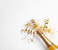 Bottle of champagne with gold glitter, confetti on white background, top view. Hilarious celebration Royalty Free Stock Photo