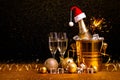 A bottle of champagne in a golden bucket with ice and two glasses Royalty Free Stock Photo