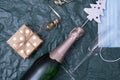 A bottle of champagne, a mask and a gift lies on the table