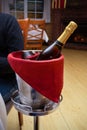 Bottle of champagne in metal ice bucket with red towel on stand in interior of restaurant Royalty Free Stock Photo