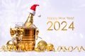 A bottle of champagne with a red santa claus cap in a golden bucket with ice and two glasses Royalty Free Stock Photo