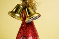 Bottle of champagne with red sparkles and golden Christmas bells on a background of yellow whatman Royalty Free Stock Photo