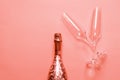 Bottle of champagne  or sparkling wine with a couple of glasses on pink background Royalty Free Stock Photo