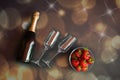 Bottle of champagne and two empty glasses on horizontal position and bowl of strawberries. Royalty Free Stock Photo