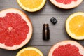 Bottle of citrus essential oil and fresh fruits on wooden table, flat lay Royalty Free Stock Photo