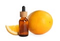 Bottle of citrus essential oil and fresh oranges on background Royalty Free Stock Photo