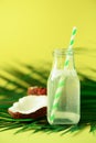 Bottle of coconut water and fresh ripe fruits on yellow background. Summer food concept. Vegetarian, vegan, detox drink Royalty Free Stock Photo