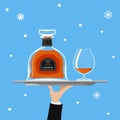 Bottle of cognac and glass on tray on blue background Royalty Free Stock Photo