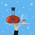 Bottle of cognac and glass on tray on blue background Royalty Free Stock Photo