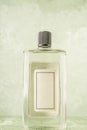 Bottle of cologne with empty label over green Royalty Free Stock Photo