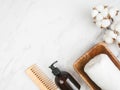 Bottle container with pump mock up, towel, wooden hair comb on white marble background Royalty Free Stock Photo