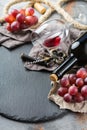 Bottle, corkscrew, glass of red wine, grapes on a table