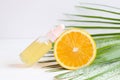 Bottle of cosmetic skincare serum with dropper, orange and palm leaf. Citrus essential oil with Vitamin C. Selective Royalty Free Stock Photo