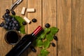 Bottle cup and bunch of grape and vine leaf on wooden background. Top view with copy space Royalty Free Stock Photo