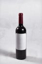 Bottle of dark red wine, red cap and white label without letters or marks Royalty Free Stock Photo