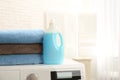 Bottle of detergent and clean towels on washing machine indoors, space for text. Royalty Free Stock Photo