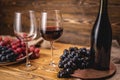 Bottle of dry red wine with a glass and a bunch of grapes on a wooden table. Concept of viticulture and winemaking Royalty Free Stock Photo