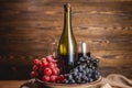 Bottle of dry red wine with a glass and a bunch of grapes on a wooden table. Concept of viticulture and winemaking Royalty Free Stock Photo