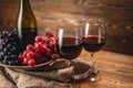 Bottle of dry red wine with a glass and a bunch of grapes on a wooden table. Concept of viticulture and winemaking Royalty Free Stock Photo