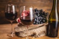 Bottle of dry red wine with a glass and a bunch of grapes on a wooden table. Concept of viticulture and winemaking Royalty Free Stock Photo