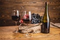 Bottle of dry red wine with a glass and a bunch of grapes on a wooden table. Concept of viticulture and winemaking Royalty Free Stock Photo